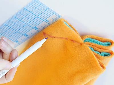 Bring them to the center where we stitched before, and again use a hand sewing needle to tack all the layers of fabric