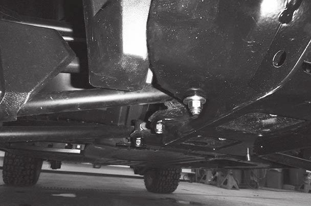 Use 3/8" x 1-1/4" cap screws and locknuts in the rear holes, as shown. 5. Insert a shim plate between the skid plate assembly and the passenger-side bracket.
