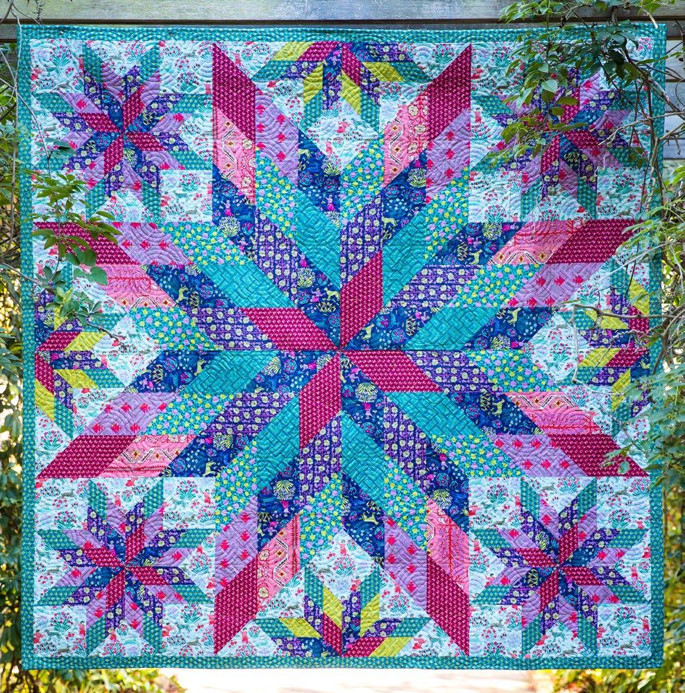Featuring Splendor by Amy Butler Blazing Star blocks and Half-Star triangles create a vibrating constellation surrounding the large star in the center of this colorful quilt.
