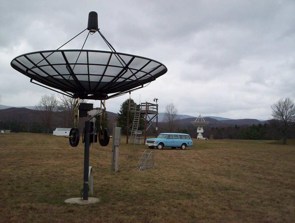Figure 3.9: 3.6m reference antenna in front of RFI enclosure for positioner control boxes, with the Green Bank 20 Meter Telescope in the background.