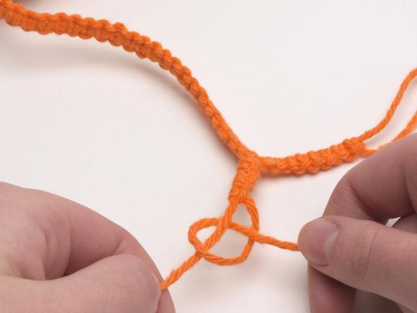 Tie a sennit of square knots to make a strap. Finish by splitting the 4 strands into 2 pairs, with 2 on each side to form a buttonhole.
