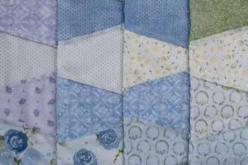 Starting at your sewing machine at the top right corner of your quilt, and with the quilt facing up, fold over the right row and sew the connected columns together top to bottom, matching bow seams.