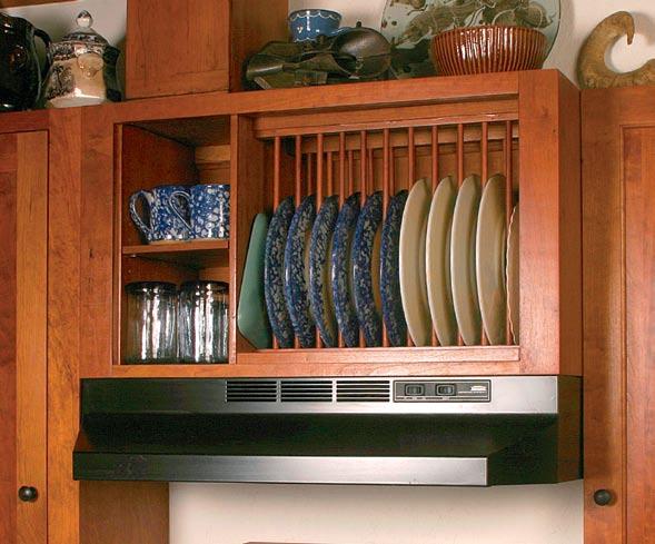 Shaker-style knobs are painted with oil-based black enamel. DETAIL S Peg rack below upper cabinets. Open plate racks above stove. Upper storage spaces, open and closed.