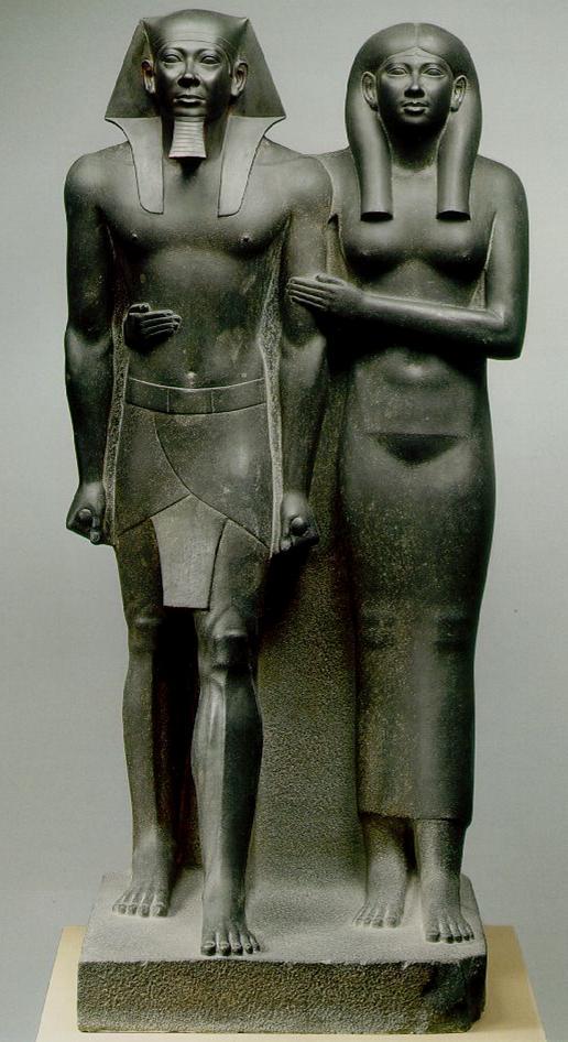 Menkaure and His Wife Menkaure is portrayed in a traditional stiff pose rigid, frontal, clenched fists and left foot placed forward stepping into eternity.