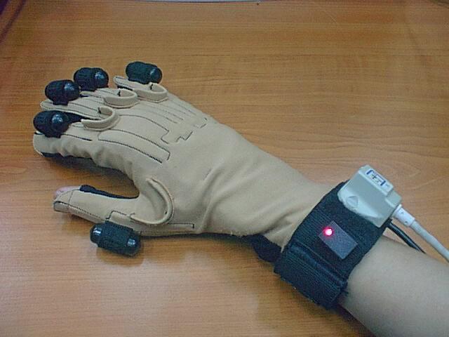 4. Employs ultrasonic system (back of glove) to track roll of hand (reported in one of twelve possible roll positions), ultrasonic transmitters must be oriented toward the microphones to get accurate