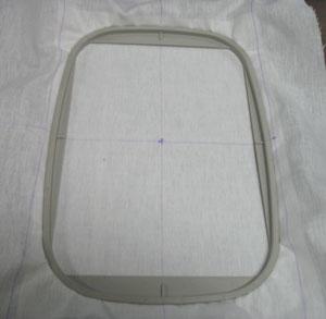 Cut a piece of sticky-back stabilizer a bit larger than your hoop, and smooth the fabric on top.