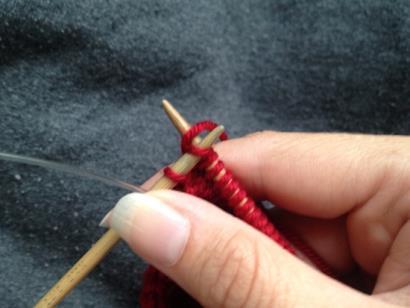 Continue to slide the right needle out of the stitches, so the stitches now rest on the