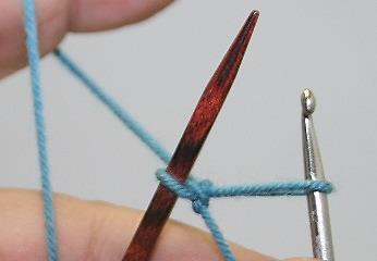 1 Take the crochet hook into your right hand and the knitting needle