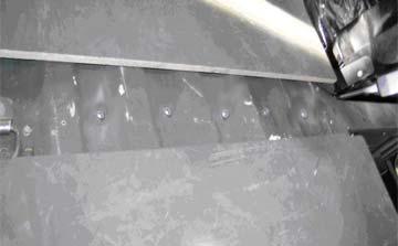 Identify and drill out the five (center) rivets in the area located above the cross member.
