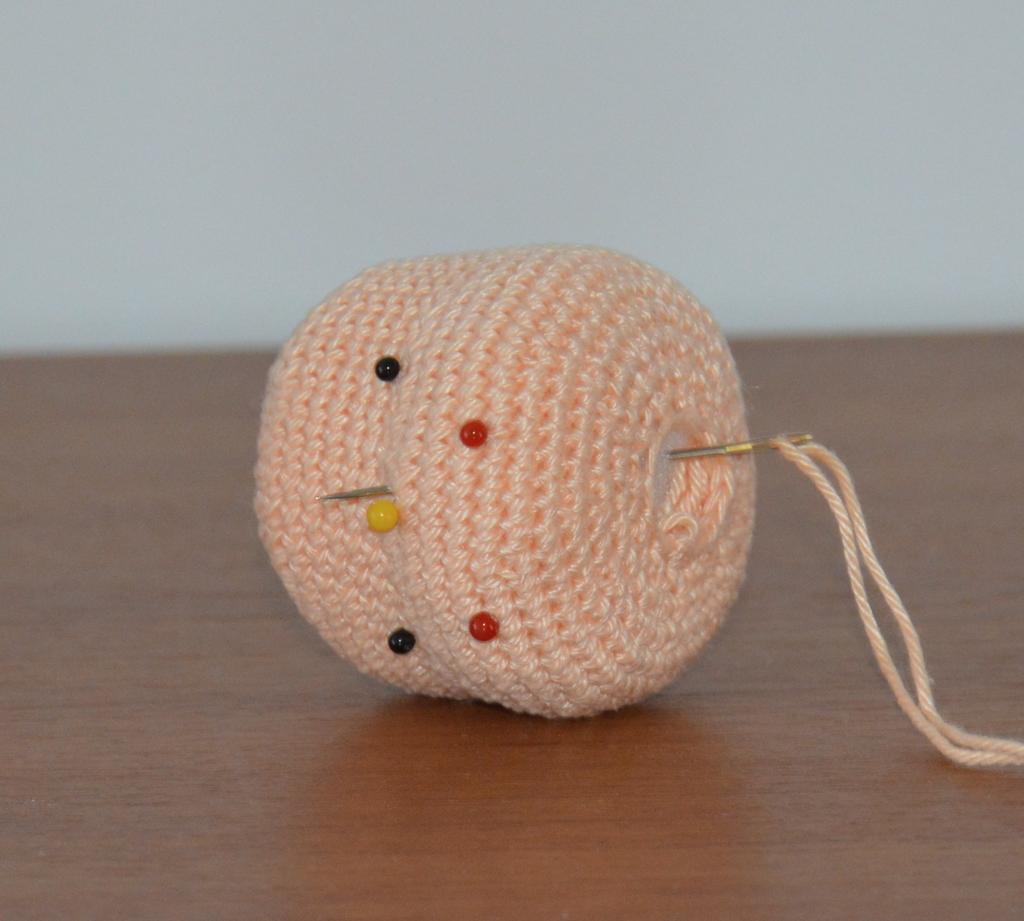 Thread your darning needle with the same yarn you used for crocheting your head and starting from the bottom head opening push the needle towards the nose area.