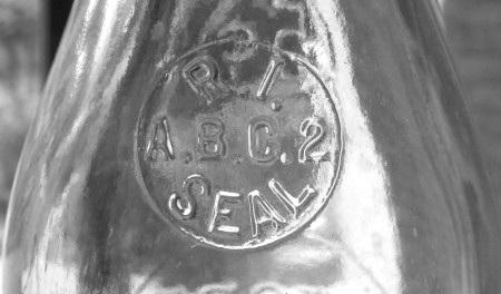 The seals were consistently embossed R.I. (arch) / 11 / SEAL (inverted arch) in a circular format on milk bottle shoulders (Figure 1).