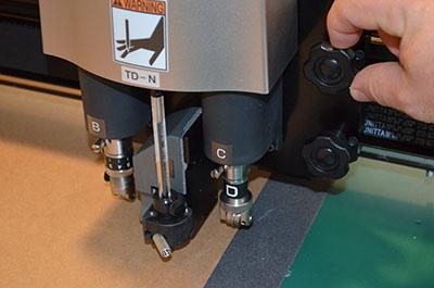 Tighten the thumb screw and inset the blade holder back into the machine using the provided screwdriver.