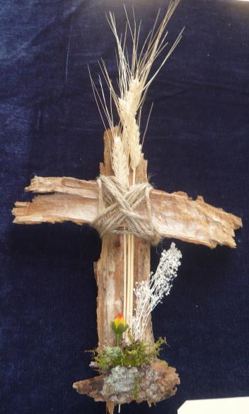 A cross created with tree bark, twine, wheat stalks, dried