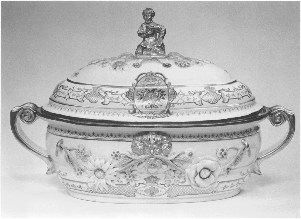holding a bowl. The scrolled handles are outlined in gold, the rims of the tureen and cover in silver. The tureen is part of a service whose original size and composition are uncertain.