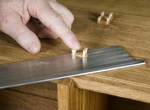 The piece is clamped firmly to the bench, making it easy to cut off the excess on the joints and plane them clean.