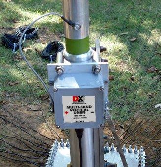 Connect the other terminal on the DXE-UN-43 UNUN closest to the Black " " on the label to the closest radial wire bolt on the optional DXE-RADP-3 Radial Plate as shown below.