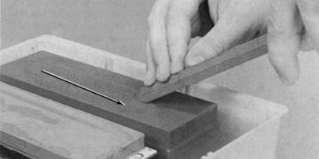 Figure 24-29. Point the cutting edge away from the direction you are sliding the tool. Figure 24-30. Position the sharpening guide within 1/16 of the belt and clamp it to the table.