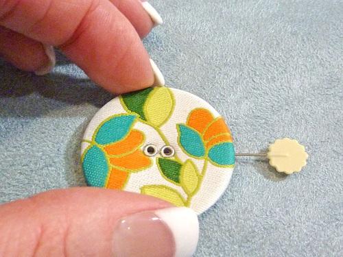 Bring the needle up through one hole of the button, then down through the hole across