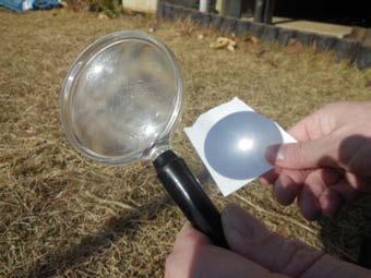2. Use the magnifying glass to focus the sunlight onto a white piece of paper and observe. 3.