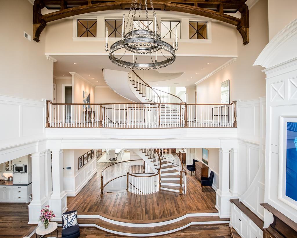 2018 StairCraft Awards Aesthetic value: Free-standing quadruple stacked curved stairways elegantly designed with reclaimed oak salvaged from historic barns to be the focal point of an engineering