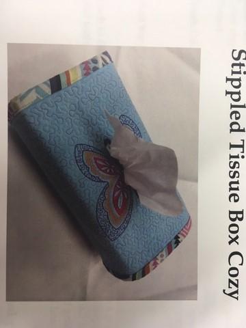 This month, I will show you how to create a stippled tissue box cozy. We will use a large embroidered button hole to create the opening and IQ Designer to create our quilting.