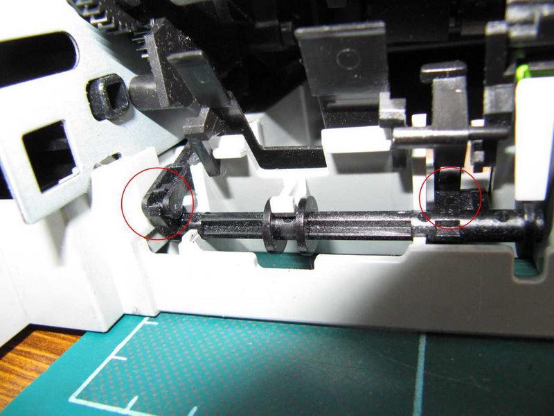 Step 14 The entire print mechanism can be removed from the base. First, release a lever at the left hand side of the back of the printer from its clip on a spindle.