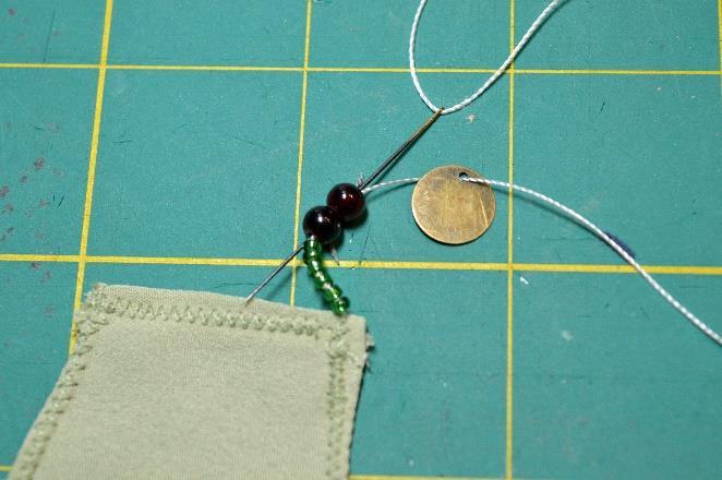 Knot your thread and bring it up from the wrong side of the scarf on the bottom corner of