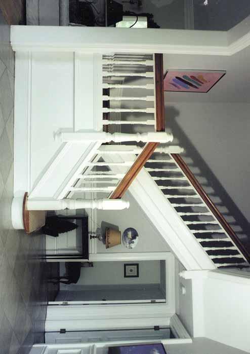 Closed Stringer Staircase Face mouldings on stringers with 1 1/8" maple tread 5" custom newel posts extending through floor with finial on top