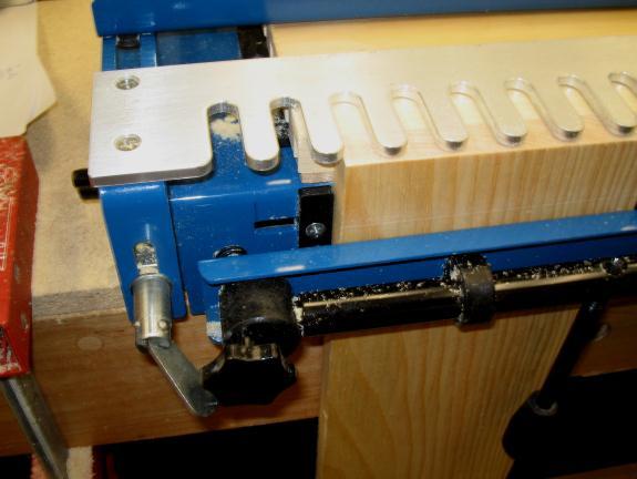 If making a cabinet or drawer, place the tails on the side pieces for maximum strength. To produce this joint, the tails are cut first using the straight template and a ½ 8-deg router bit and 7/16 O.