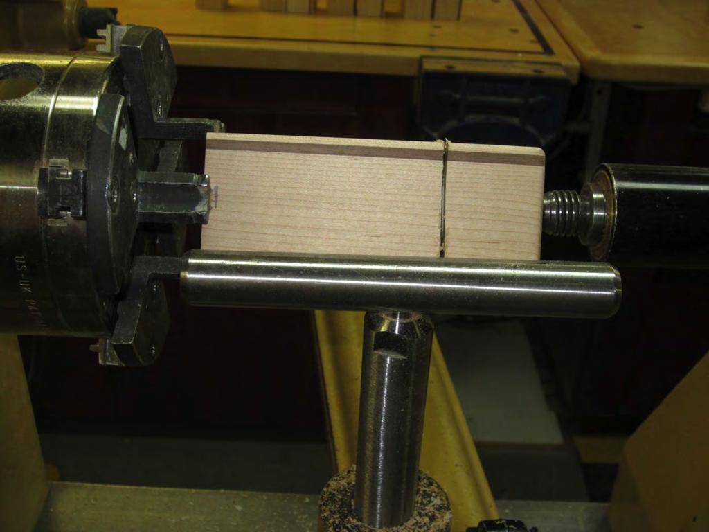 Using a thin parting tool at the 1½ mark at the waist, plunge just far enough to see the walnut strip.