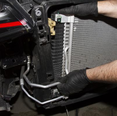 Unclip the radiator from the intercooler by pressing on the upper tabs.