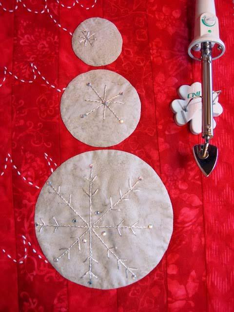 Finishing Make a quilt sandwich (spray baste or use fusible batting) and quilt around the tree shape close to all Sashiko stitches and around snowman circles.