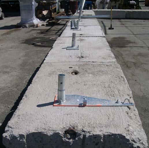 Layout and secure all Base Plates in position as shown in Figure 4. Secure the base flanges with either or both the Auger style anchor (20) and the Earth style anchor (21).