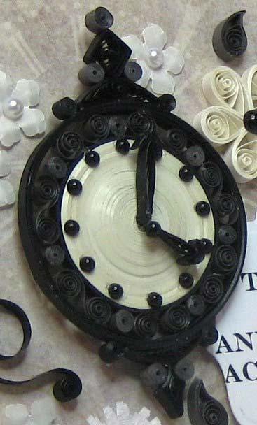 I used several light cream strips to make the face of the clock and then made tight coils and s shapes for the outside rim and peaks.