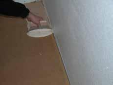 Spread adhesive over the subfloor where the whole row of boards will lie.