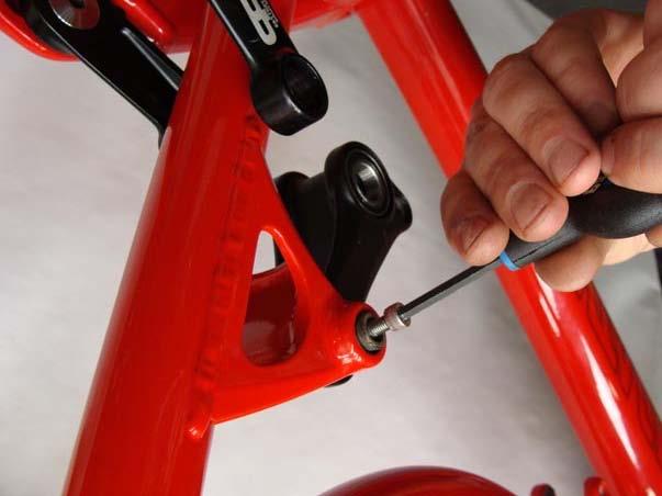 Step 3: Remove Upper Link 1. a) Using a 4mm Allen wrench, remove the bolt from the upper pivot of the upper link. 2. b) Use the same Allen wrench to remove the tapered washer from the pivot axle.