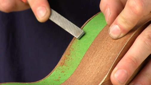 With a flat sanding block, follow the outer curves of the body to flush the edges with the sides.