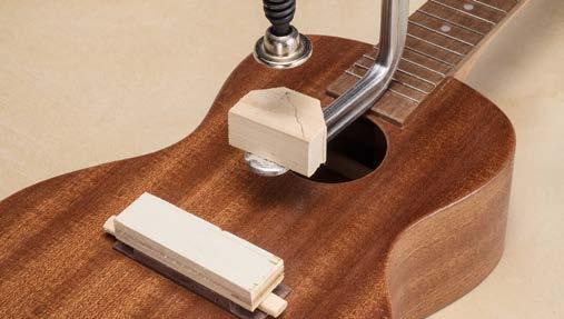 Line the tuners up so they stick out at right goes toward the neck, and the string tie block goes toward angles, not crooked. Use a sharp awl to mark the tuner the tail. mounting holes.