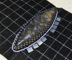 Use size 11 seed beads to surround your center stone. Do this with backstitching. It is helpful to go back through all of the 11s again to fill up the bead holes, making a smoother line.