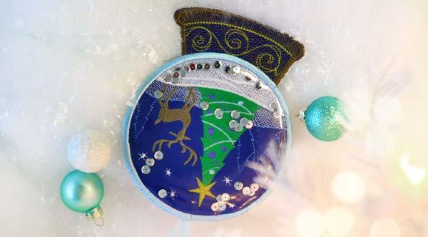 Vinyl Snowglobe Ornament (In-the-Hoop) Take a peek into a magical winter wonderland with this snowglobe ornament! Transparent vinyl applique brings a clearly unique look to this in-the-hoop design.