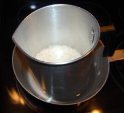 The double boiler process involves getting a pot (or roaster) and placing a few inches of water into it. Then, place your pot on the stove tops at a medium heat setting.
