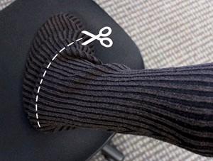 Take one of your sweater sleeves and slide it over your leg, sleeve first, with the seam of the sweater at the back.
