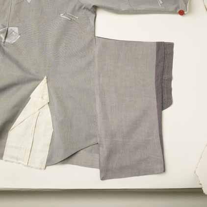 When folding the fabric airplanes, work on an ironing board and press the folds as you go. Pin to hold the shapes. Finish the hem edge of the shirt first.