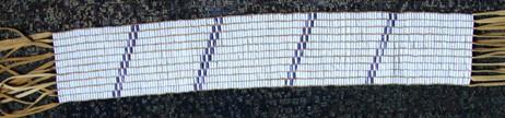 Tuscarora Land Holland Belt Not given. Beaded Length: 26.6 inches. Width: 4.5 inches. Total length with fringe: 48.6 inches. 163 columns by 10 rows. Total: 1,630 beads.