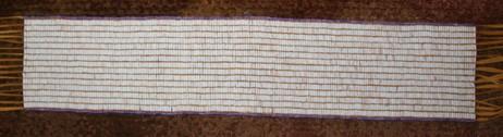 Great White Belt Undetermined Beaded Length: 34.0 inches. Width: 7.25 inches. 198 columns by 17 rows. Total: 3,136 beads. Top and bottom rows are light purple beads sown horizontally along the edge.