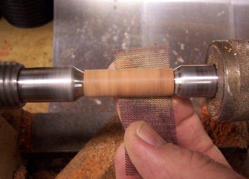 13. With the blank mounted back on the lathe between the two centers, I sand the blank down to size.