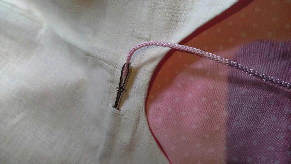 13. Thread the cord through front left front buttonhole, continue all the way