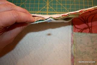 Lay bag flat and trim top corners 1/4 outside of the stitching line. Make sure no part of the bag is under the area being trimmed.