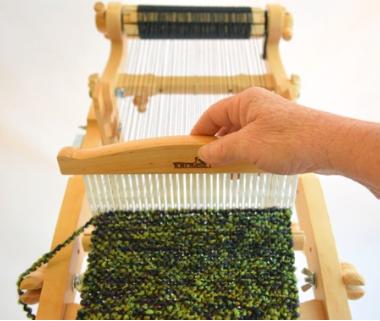 Press the yarn forward with the heddle as before. Press firmly, but not so tight that the fabric becomes stiff.