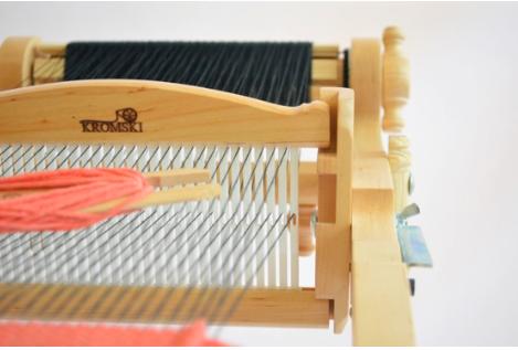 Leaving a loop of yarn hanging off the edge, pass the heddle through, from left to right. Push the weft down again with the heddle.